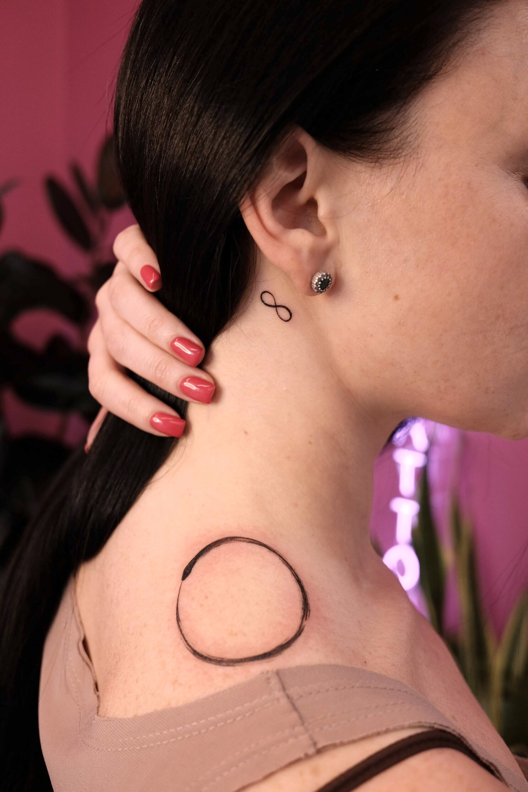 Круг на плече и знак бесконечности за ухом